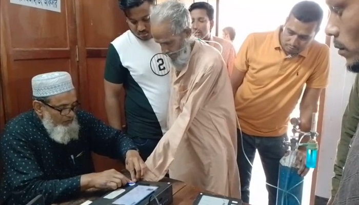 অক্সিজেন সিলিন্ডার নিয়ে ভোটকেন্দ্রে ৮০ বছরের বাকের আলী